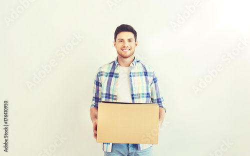 smiling young man with cardboard box at home