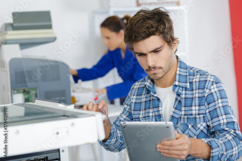 young technician working on a printer