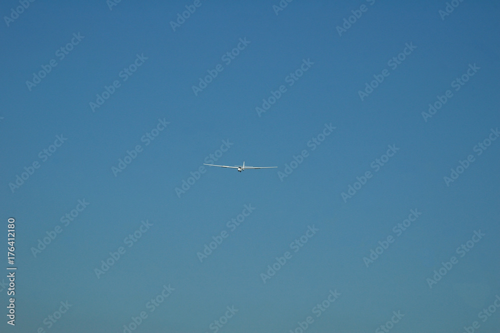 white glider on late afternoon blue sky white glider on late afternoon blue sky