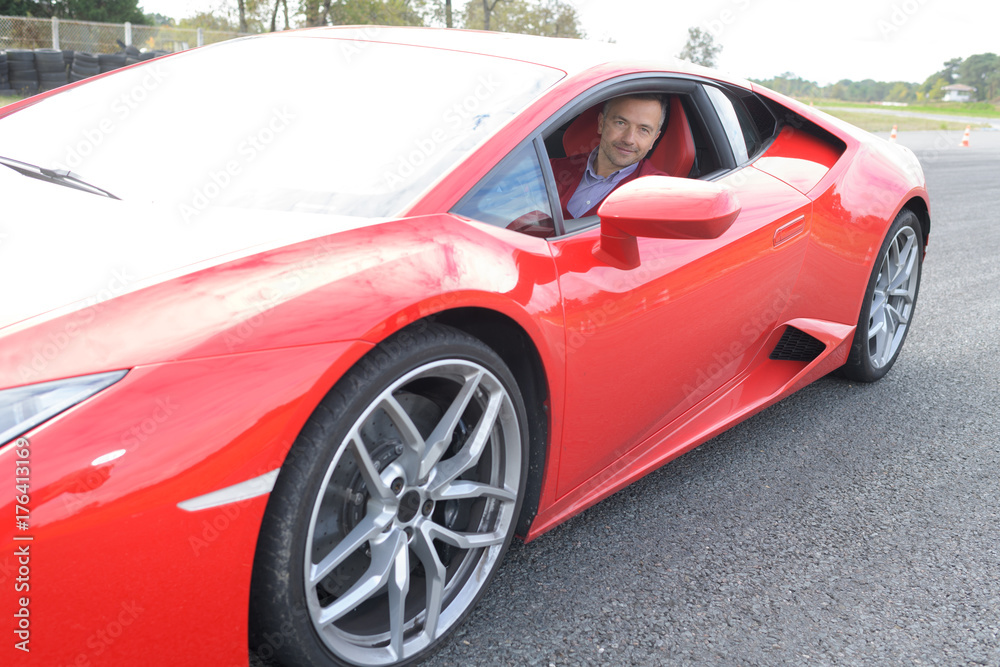 Portrait of man in red sports car