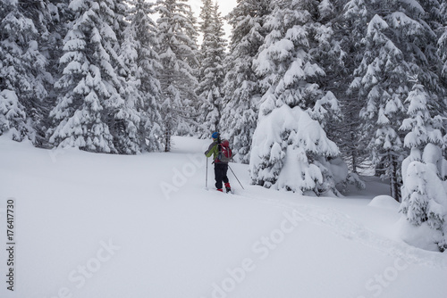 Traveler, with backpack, is walking in deep snow