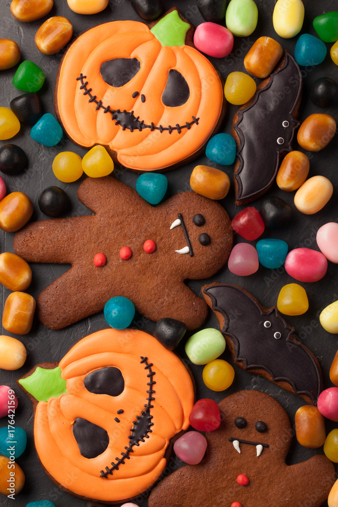 Halloween pumpkin, bat and gingerbread man-vampire cookies and colorful candy overhead shot