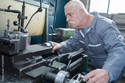 senior male carpenter cutting wood at construction site