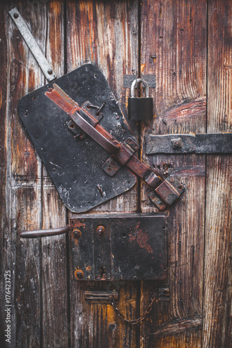 Nice photo about Old door, blacksmith metal latch lock