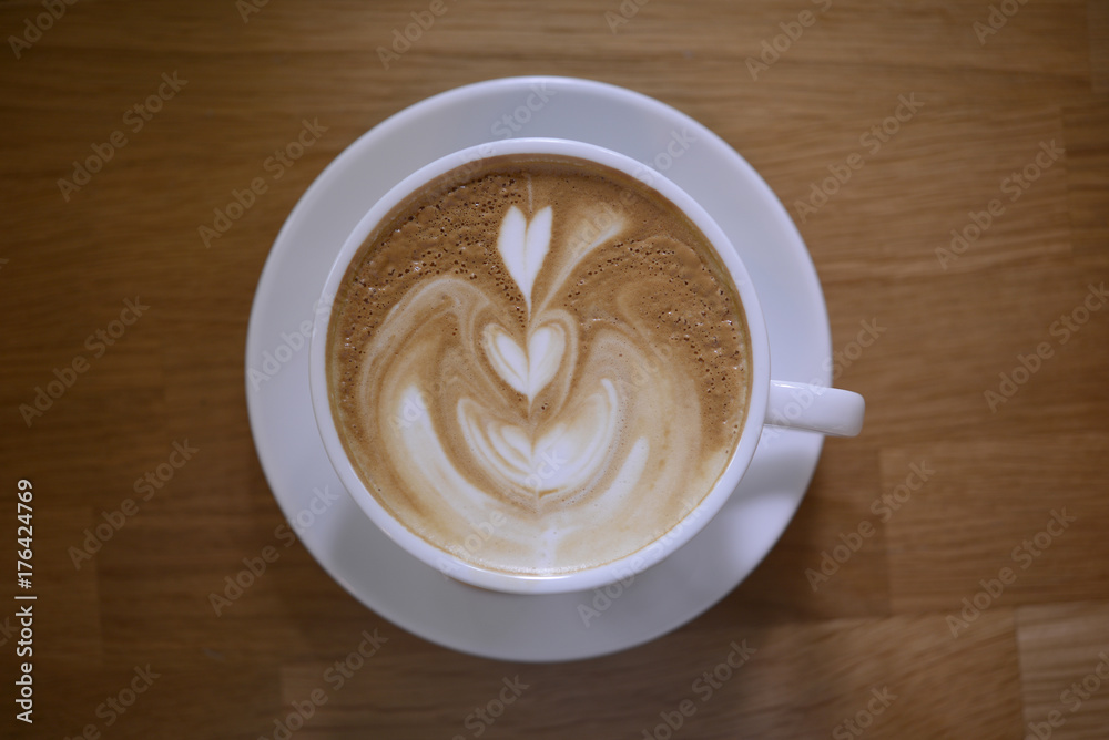 coffee latte art foam in white cup on wooden table, top view coffee latte art foam in white cup on wooden table, top view