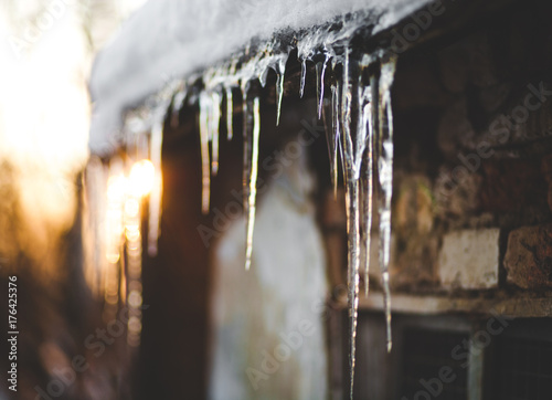 Beautiful Photo Winter, icicles hanging from the roof, sunset