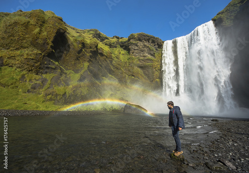 Tourist standing near Skogafoss waterfall, Iceland