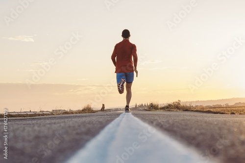 Uomo che corre su strada asfaltata