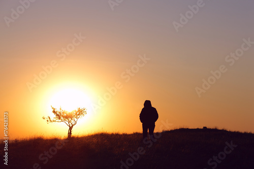 man in the mountains in the morning against the sun