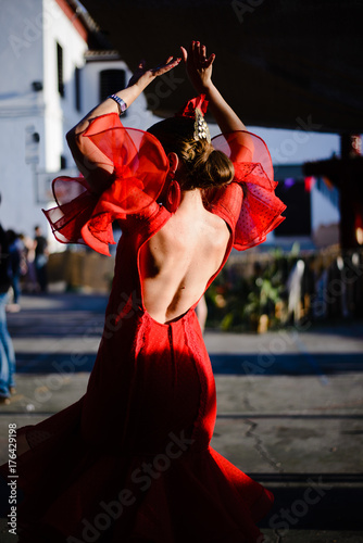 Woman from her back dancing sevillanas with a red regional costume in Granada, Spain. photo