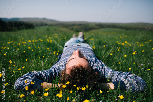 Handsome young man on the grass field on the hill in spring photo