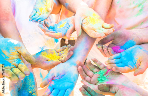 Bunch of colorful hands of friends group having fun at beach party on holi color festival summer vacation - Young people enjoying time together - Youth friendship concept with multicolored powder game