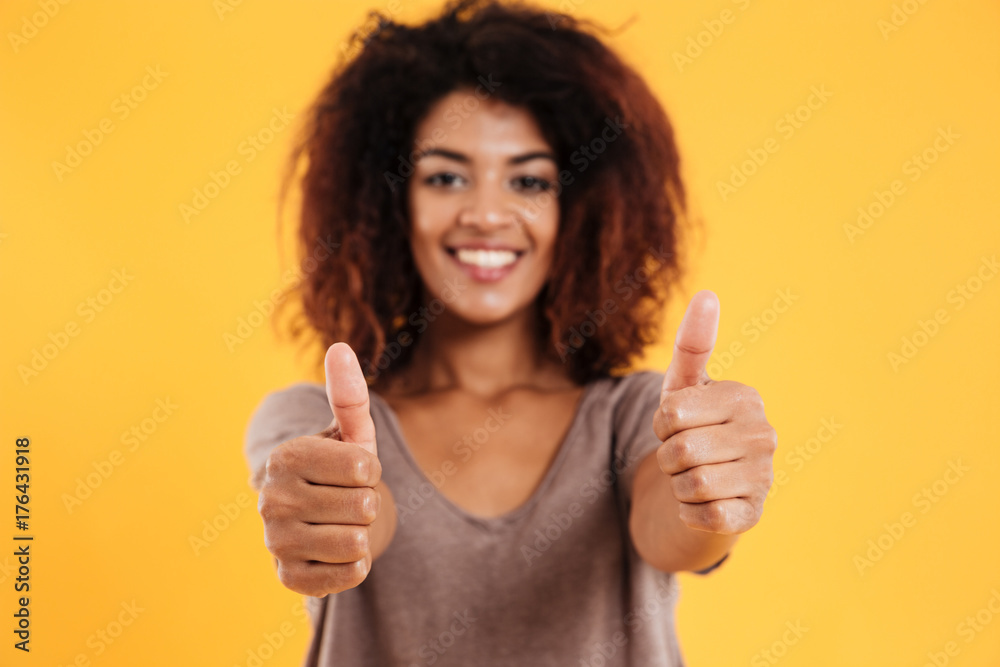 Happy cheerful brunette woman showing thumb up and smiling isolated Happy cheerful brunette woman showing thumb up and smiling isolated