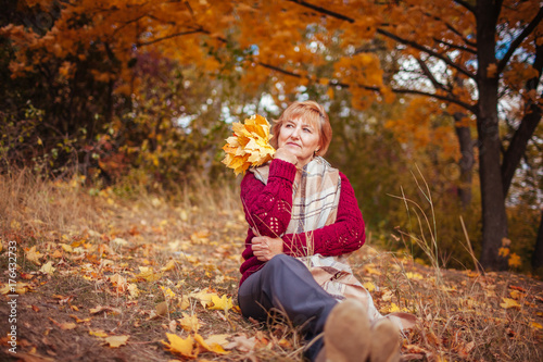 Middle-aged woman relaxes in autumn forest