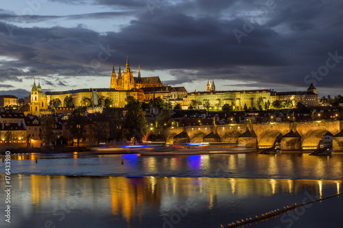 View of Charles Bridge, Prague Castle and St. Vitus cathedral in twilight with dramatic sky.Prague. Czech Republic .