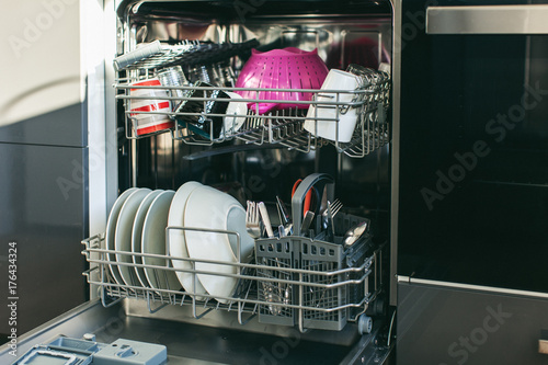 Cleaned dishes in open dishwasher.
