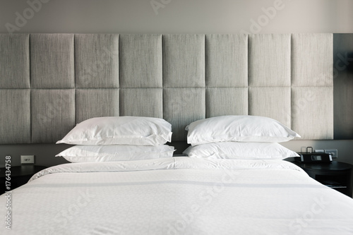 modern bed with white sheet and grey headboard photo