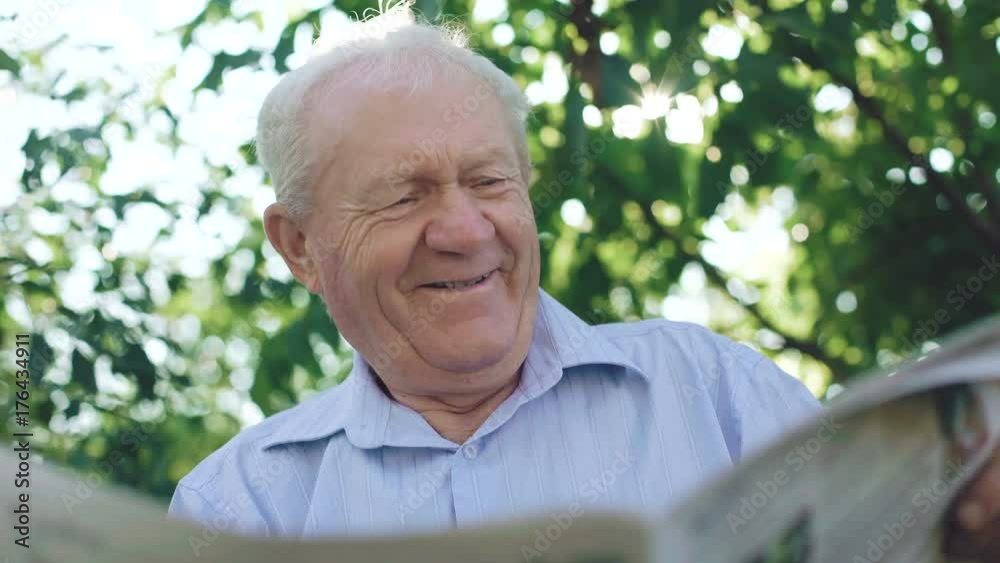 Handsome senior reading the newspaper in the garden. 4K Handsome senior reading the newspaper in the garden. 4K