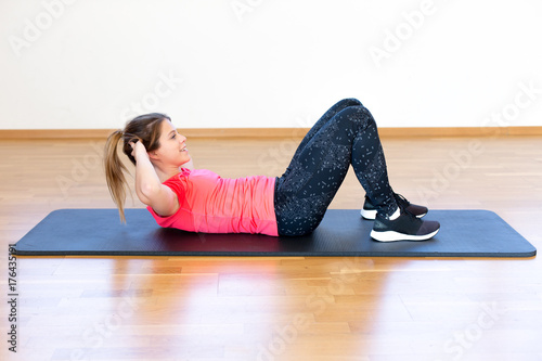 Active young woman exercising photo