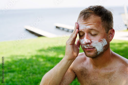 man applying a ridiculous amount of sunscreen photo