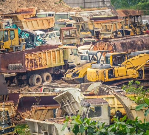 junkyard full of colorful heavy machinery in the valley surrounded by vegetation