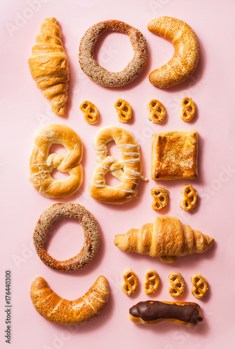 Miscellaneous types of pastry arranged in order on pink backgorund. photo