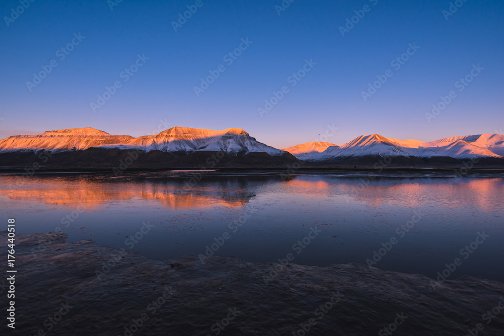 Landscape of a nature of a  pink sunset  in the reflection ocean mountains of Spitsbergen Svalbard near the Norwegian city Longyearbyen