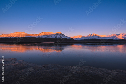 Landscape of a nature of a pink sunset in the reflection ocean mountains of Spitsbergen Svalbard near the Norwegian city Longyearbyen