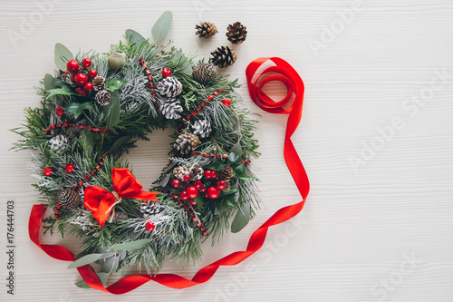 Homemade Christmas wreath on white wooden table
