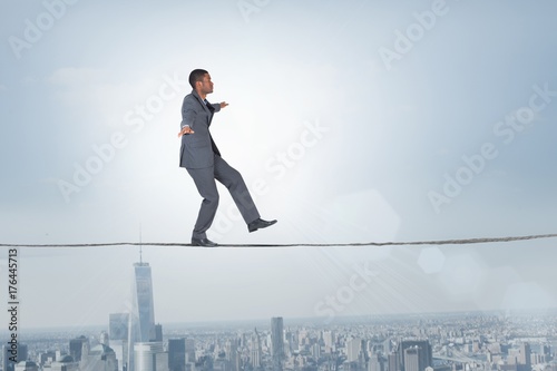 Composite image of businessman performing a balancing act