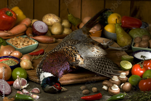 whole pheasant with raw ingredients photo