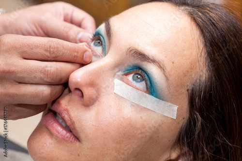 Make up artist using masking tape to create cat eyes