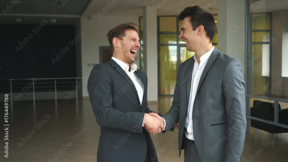 two businessmen met in the office and shake hands two businessmen met in the office and shake hands