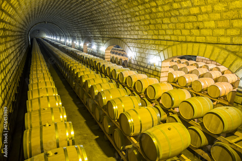 Wine barrels stacked in the cellar of the winery
