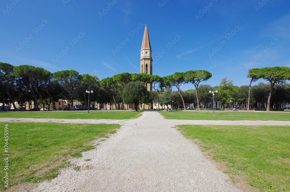 The bell tower of the church of Arezzo, Tuscany, above a public park.