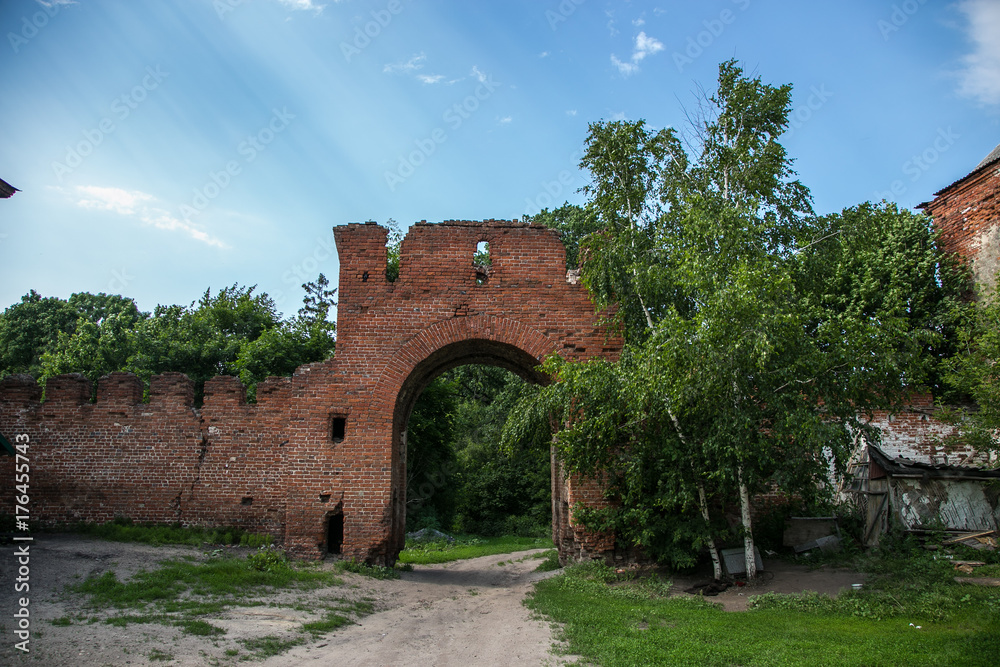 Abandoned and overgrown gateway of red brick to former Kikin Ermolov's manor, Ryazan region, Russia