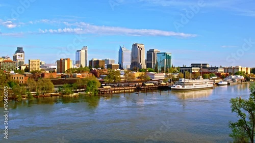 Cinematic aerial of Sacramento downtown, capital of California state from waterfront view with docked boats, highway traffic and railroad trains on a hot sunny summer day  photo