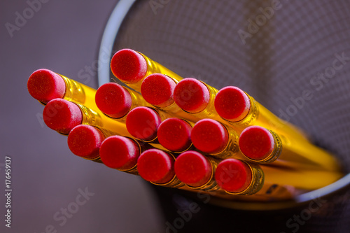 Close up image of jar with yellow pencils with red eraser.