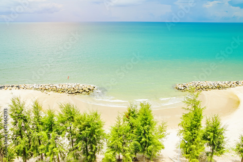 summer clean beachfront with small rock dam and sunshine , bird's eye view