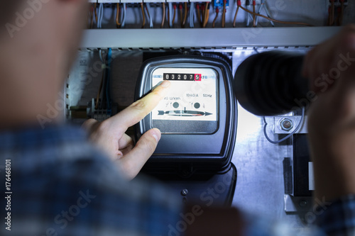 Bild auf Leinwand Finger Pointing To Electric Meter Reading