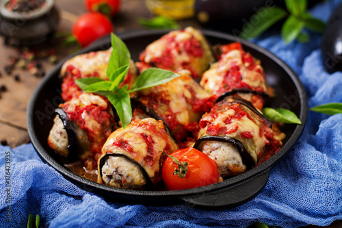 Eggplant (aubergine) rolls with meat in tomato sauce. Flat lay. Top view