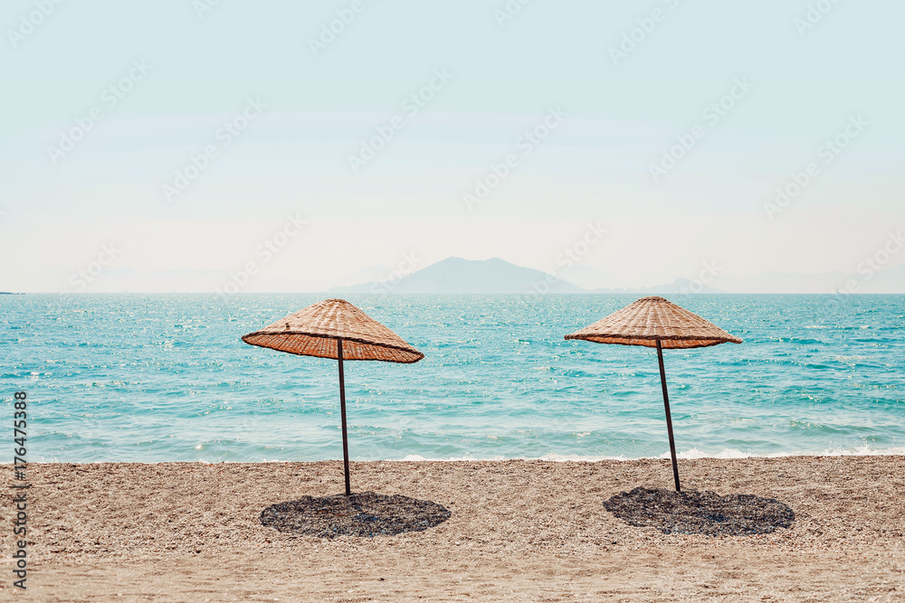 pure tropical island beach with two hut umbrellas