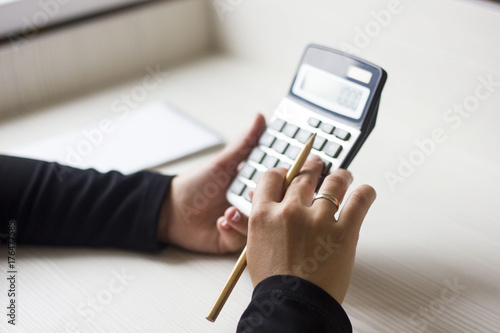 Wallpaper Mural female hands counting on calculator and holding a pencil Torontodigital.ca