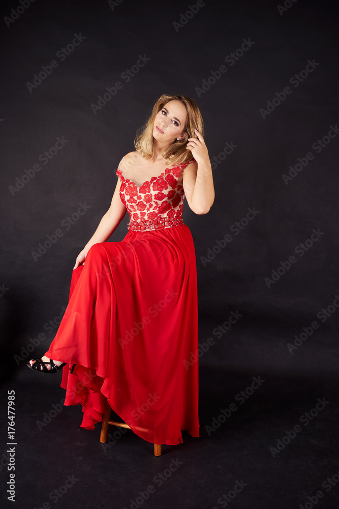Studio shot of young woman in long red dress