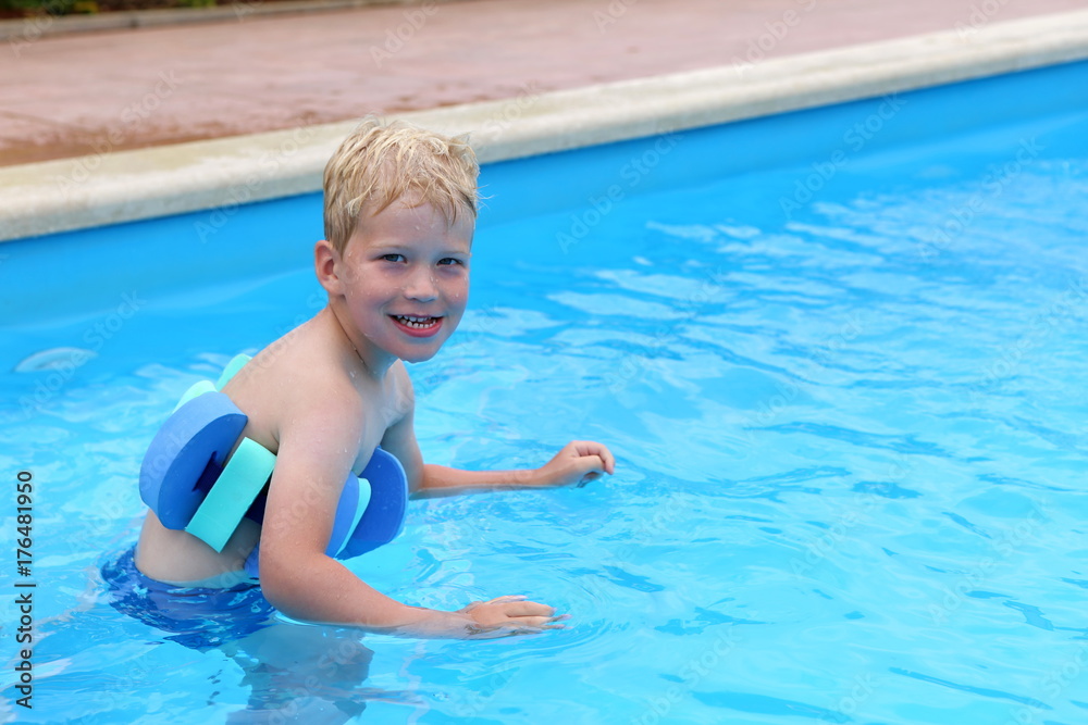 Little boy in the swimming pool with the swimming aid