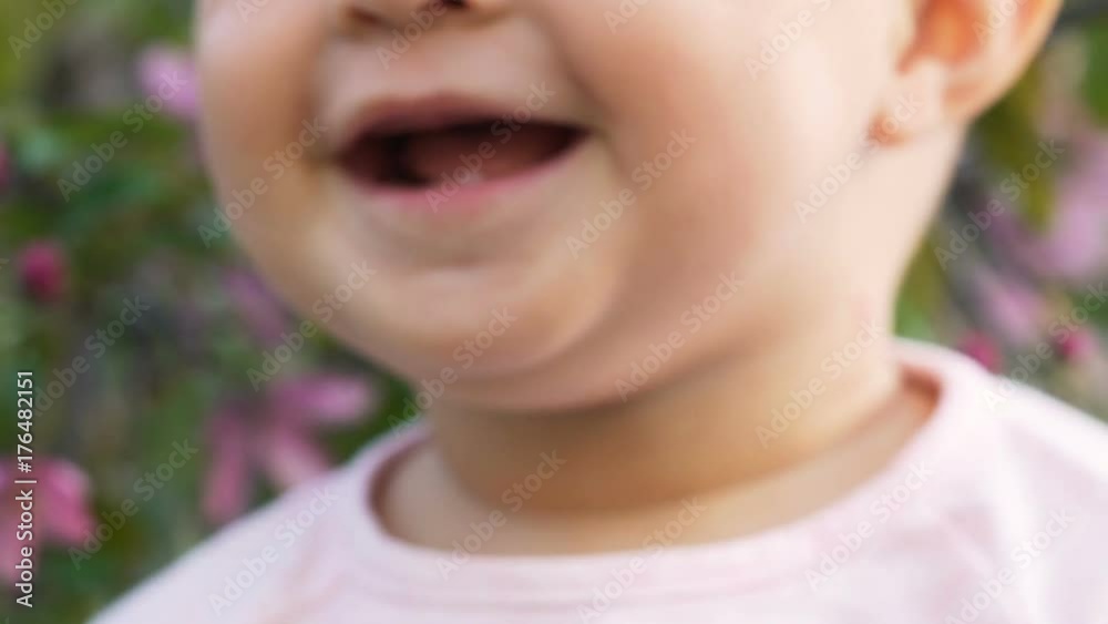Sweety little happy cute cheerful funny playing and clap hand outside at green summer area slowmotion closeup. Looking for joy around, smiling, laugh and do applause bakground flower Sweety little happy cute cheerful funny playing and clap hand outside at green summer area slowmotion closeup. Looking for joy around, smiling, laugh and do applause bakground flower