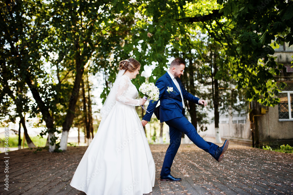 Lovely newly married couple walking in the park on their wedding day.