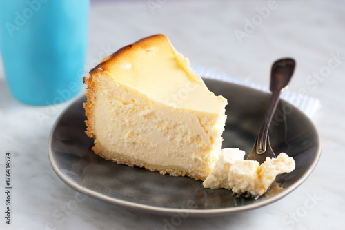 Homemade german cheesecake on beautiful plate on white table. Natural light, selective focus.