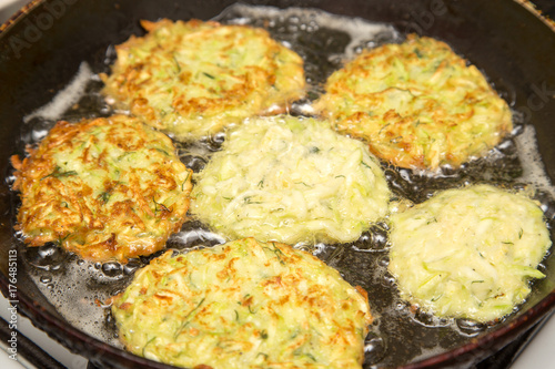 Foto Fritters are fried in oil in a frying pan