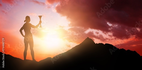 Composite image of woman posing with trophy